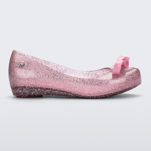 Side view of a Glitter Pink Mini Melissa Ultragirl Bow Glitter flat with a pink glitter base and pink bow