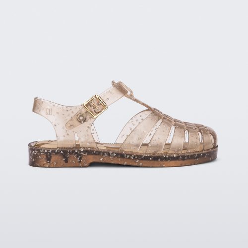 Side view of a clear beige Possession kids sandal with star glitter