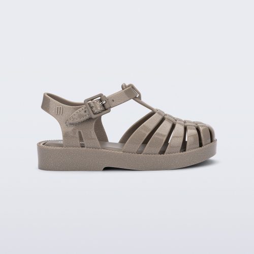 Side view of a glitter beige baby Possession fisherman style sandal.