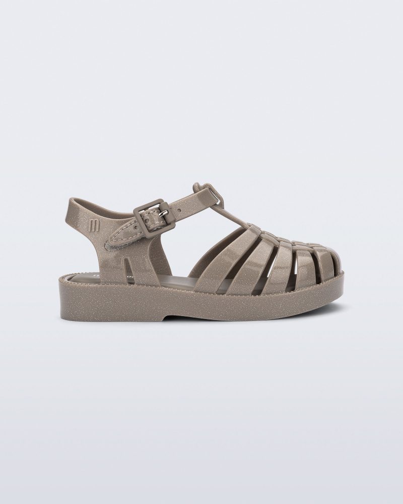 Side view of a glitter beige baby Possession fisherman style sandal.