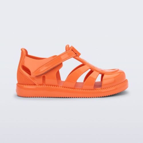 Side view of an orange baby Hip Daydream sandal