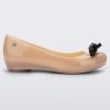 Side view of a beige Ultragirl Bow flat with black bow.