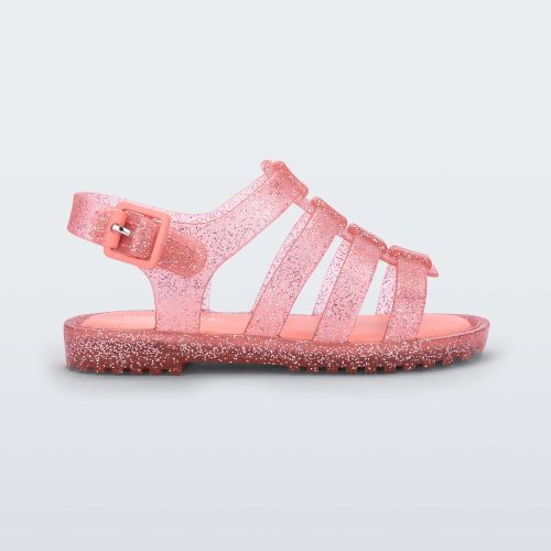 Side view of a clear pink glitter Mini Melissa Flox sandal with straps.