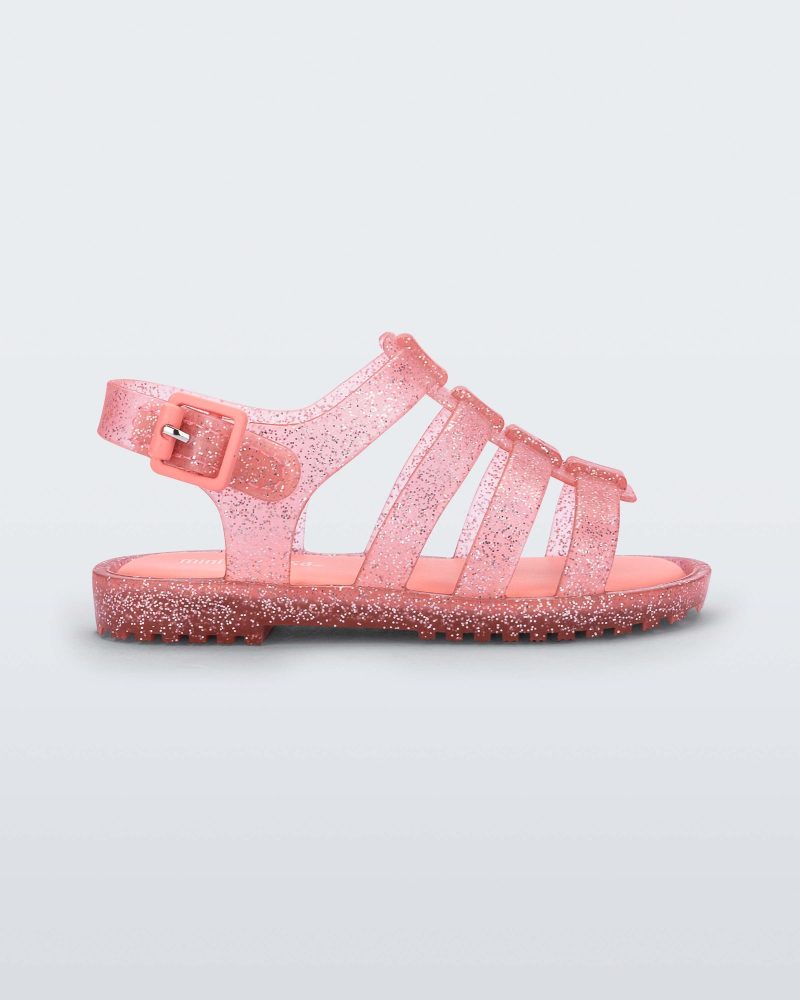 Side view of a clear pink glitter Mini Melissa Flox sandal with straps.