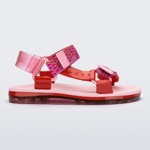 Side view of a pair of pink Melissa Papete sandals with patterned pink, red, and transparent pink straps.