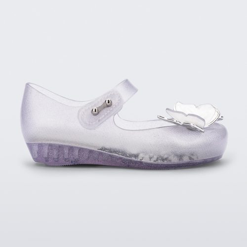 Side view of a clear glitter Mini Melissa Ultragirl Butterfly baby mary jane flat with two metallic and clear butterflies and peep toe.