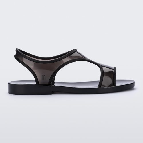 Side view of a transparent black Melissa Bikini Sandal with two transparent black straps conjoining in the middle and a black insole.