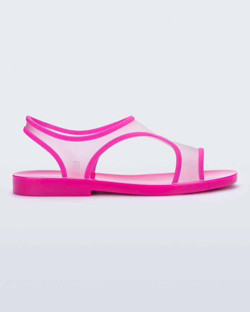 Side view of a transparent neon pink Melissa Bikini Sandal with two transparent pink straps conjoining in the middle and a pink insole.