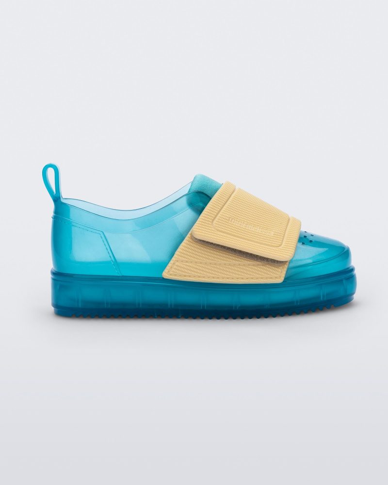 Side view of a blue/yellow Mini Melissa Jelly Pop Sneakers with a blue base and a yellow velcro strap.