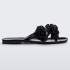 Side view of a black Melissa Harmomic Squared Garden flip flop with flowers on the straps.