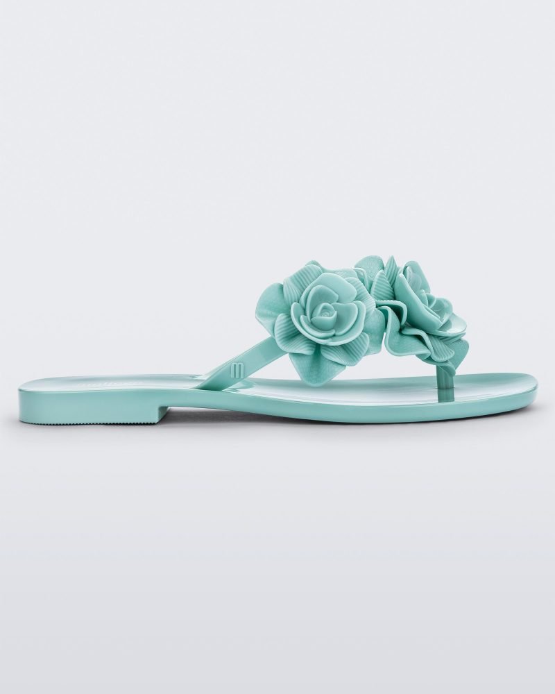 Side view of a green Melissa Harmomic Squared Garden flip flop with flowers on the straps.