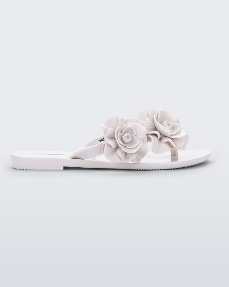 Side view of a white Melissa Harmonic Garden flip flop with flowers on the straps.