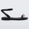 Side view of a black/gold Melissa Dare sandal with a gold metal chain buckle.