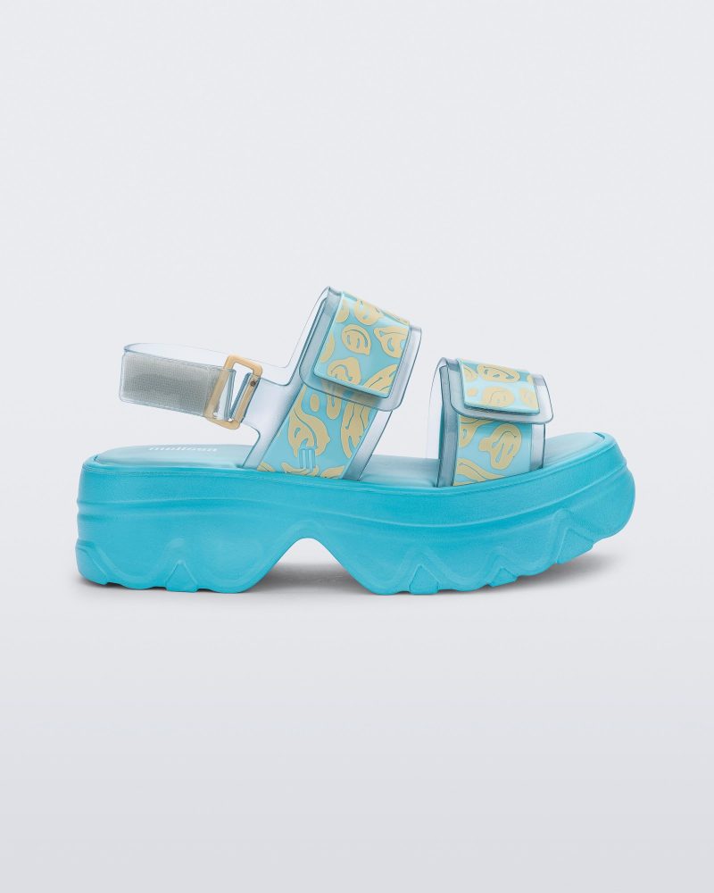 SIde view of blue Melissa Brave Platform sandals with smiley face print on straps.