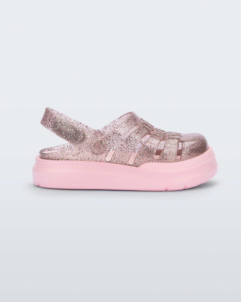 Side view of a pink/glitter Mini Melissa Sunday sandal with a glitter base, closed toe front and pink sole.