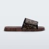 Side view of a brown / black Melissa Brave slide with a black and brown patterned velcro top strap and translucent brown insole.