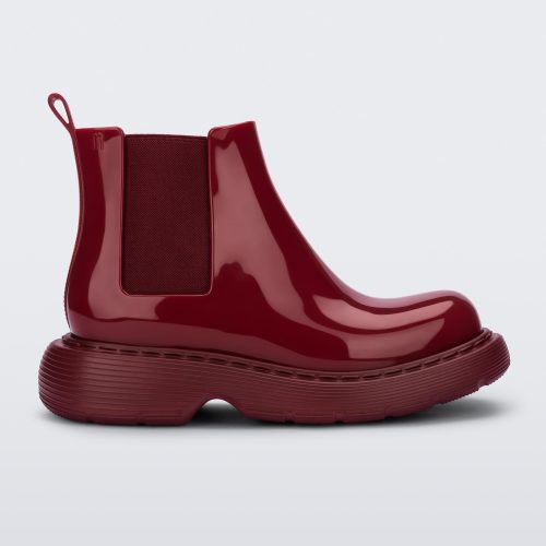 Side view of a Melissa Step slip on ankle boot in Red with stretch side detail and lugg sole