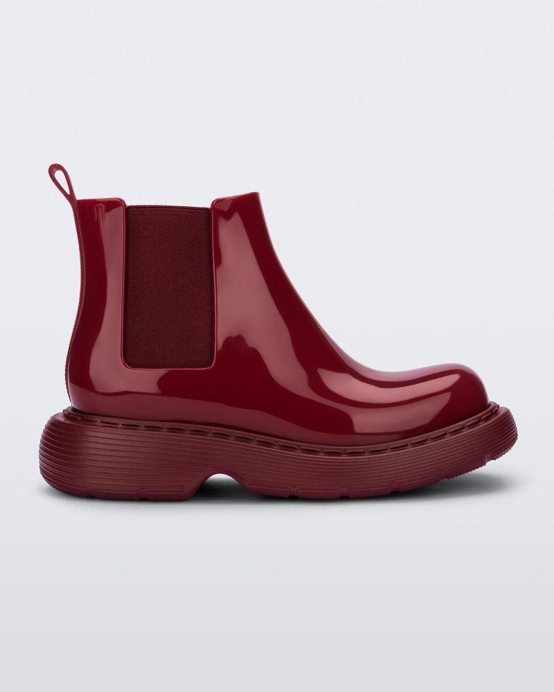 Side view of a Melissa Step slip on ankle boot in Red with stretch side detail and lugg sole