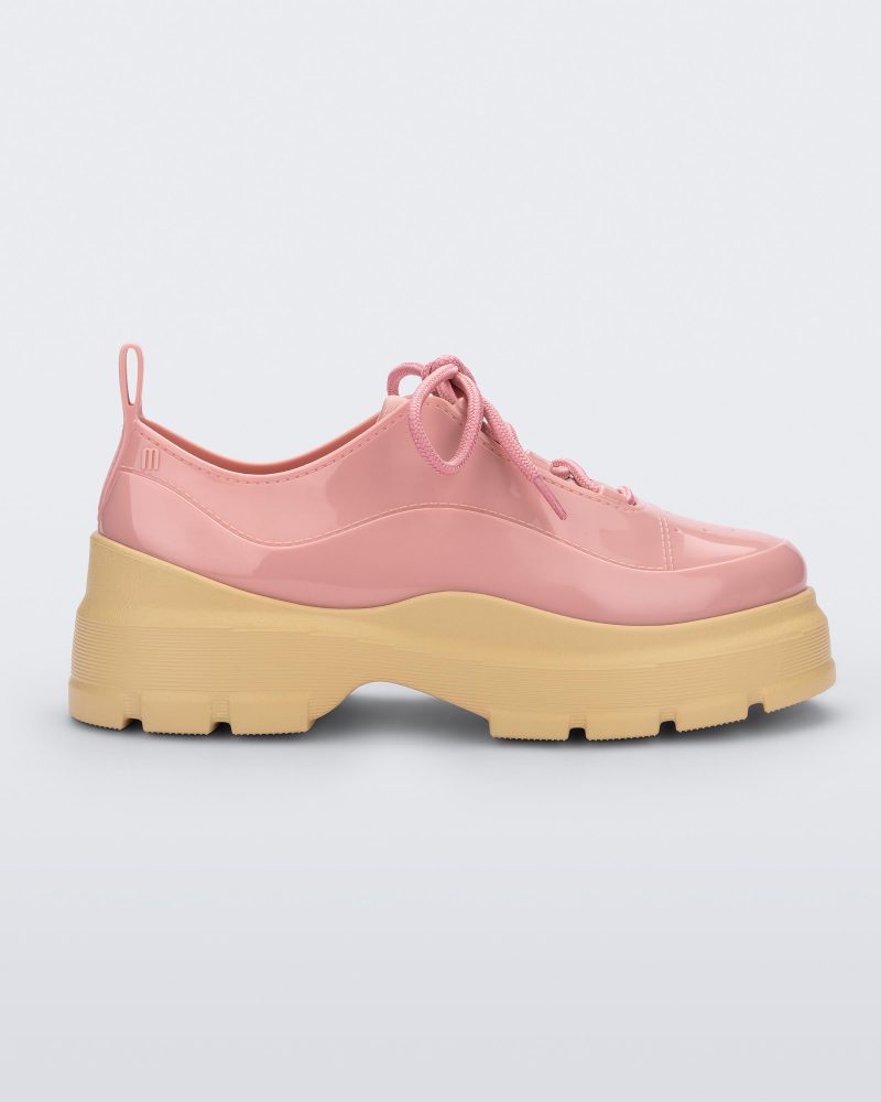 Side view of a pink Melissa Funky sneaker with pink laces and a chunky yellow sole.