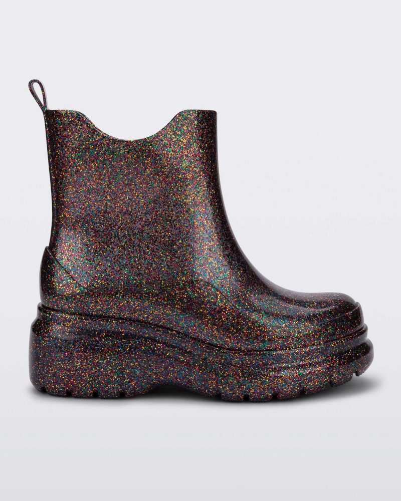 Side view of a clear glitter Melissa Grip multicolor glitter short rain boots.