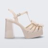 Side view of a Melissa Tie Party platform heel sandal in Beige with ankle strap and buckle closure and 3D bow detail on front straps