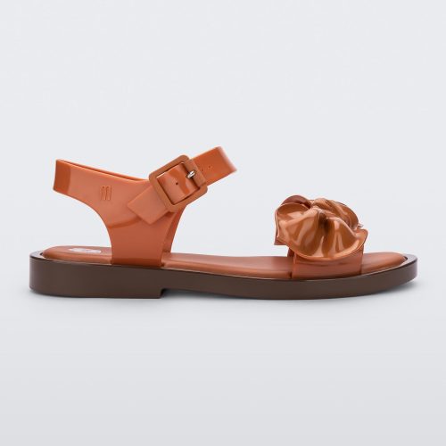 Side view of a Brown/Orange Melissa Tie Mar Sandal with an orange/brown base, an ankle strap and a front strap with a beige bow on the front.