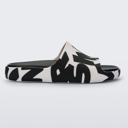 Side view of a White Logo Scramble Melissa Cloud slides with a black simon miller letter scrambled text on a white base base and a black insole reading in red 