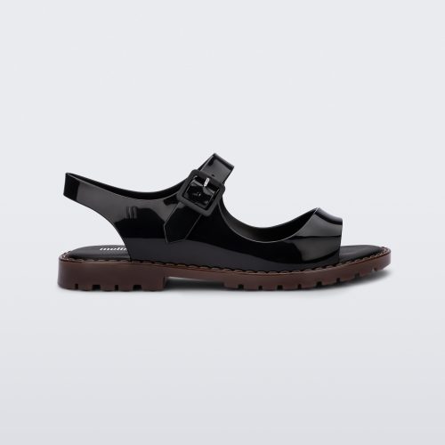 Side view of black Melissa Bae sandals with brown sole.