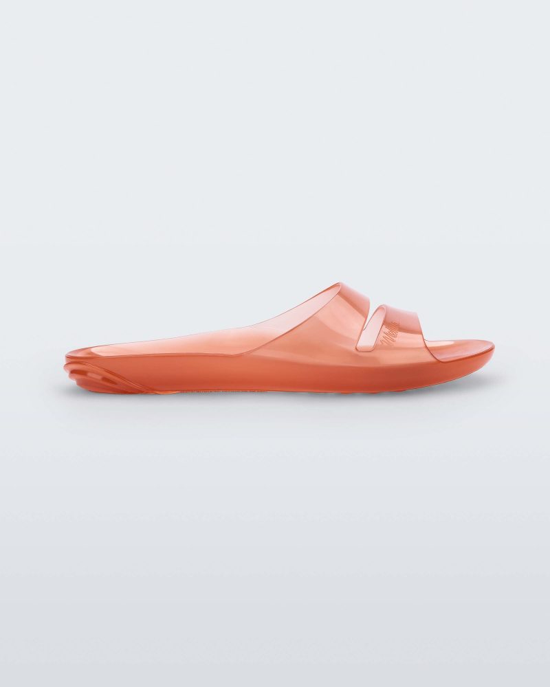 Side view of a clear orange Melissa Real Jelly Slide with two front straps.