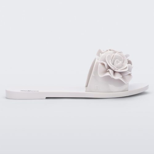 Side view of a white Melissa Babe Garden slide with two flowers on the front strap.