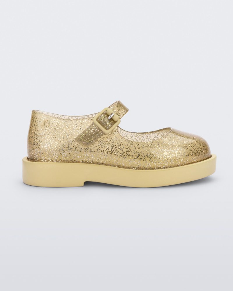 Side view of a pair of clear glitter yellow Mini Melissa Lola loafer with a rounded toe, strap and yellow buckle.