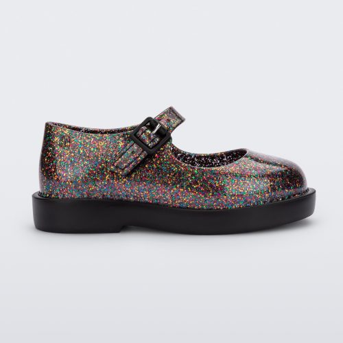 Side view of a clear multicolor glitter Mini Melissa Lola loafer with a rounded toe, strap and black buckle.