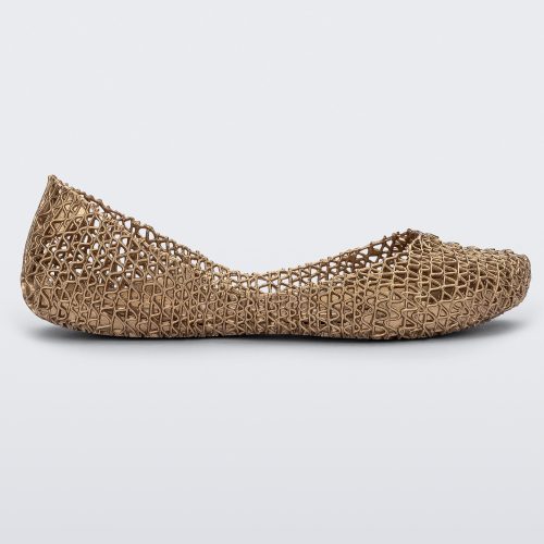 Side view of a gold Melissa Campana flat with an open woven texture.