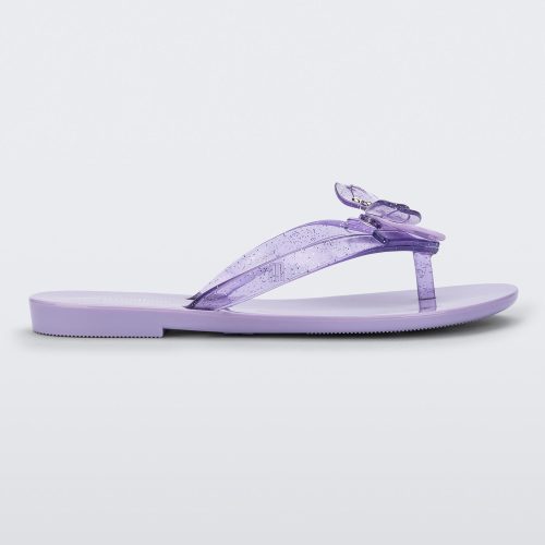 Side view of a lilac / lilac glitter Mini Melissa Harmonic Bugs flip flop with a clear glitter bug with a silver buckle on the straps.