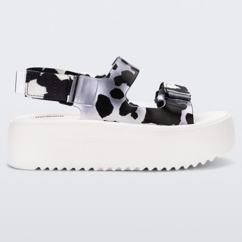 Side view of a white Melissa Brave Papete platform sandal with clear/black spotted straps.