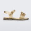 Side view of a gold glitter Mini Melissa Mar sandal with a bow.