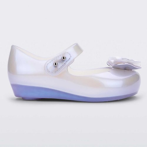 Side view of a pearly blue Mini Melissa Ultragirl flat with a top strap and a heart bow buckle on the toe.