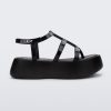 Side view of a black Melissa Caribe High Platform sandal with two black front straps joined by a vertical strap intersecting the ankle strap and a black sole.