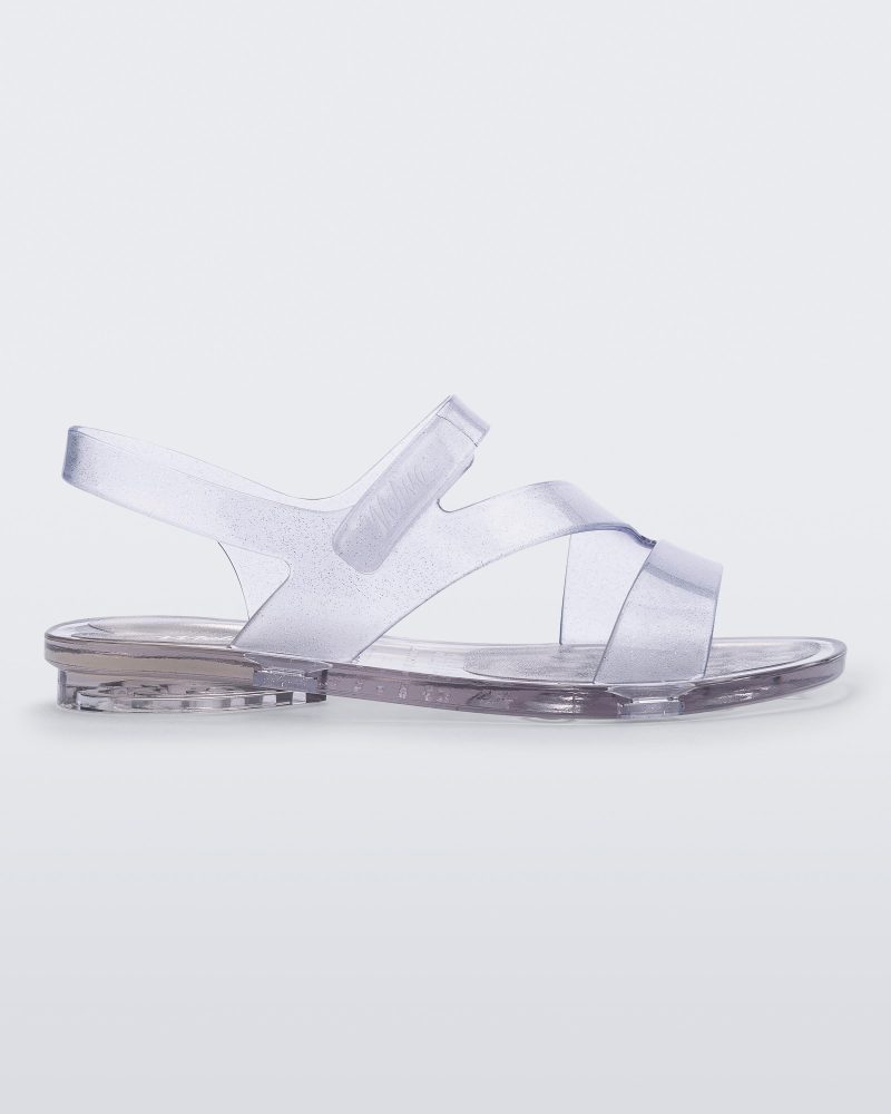 Side view of a clear Mini Melissa The Real Jelly Paris sandal with three front straps and an ankle strap.