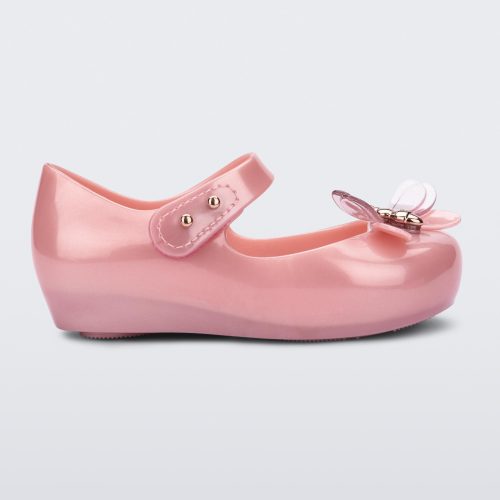 Side view of a pearly pink Mini Melissa Ultragirl Bugs flat with a top strap and a bug detail on the toe.