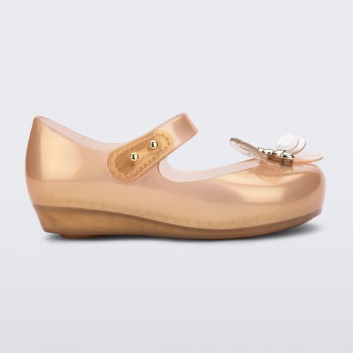 Side view of a pearly orange Mini Melissa Ultragirl Bugs flats with a top strap and bug detail buckle on the toe.