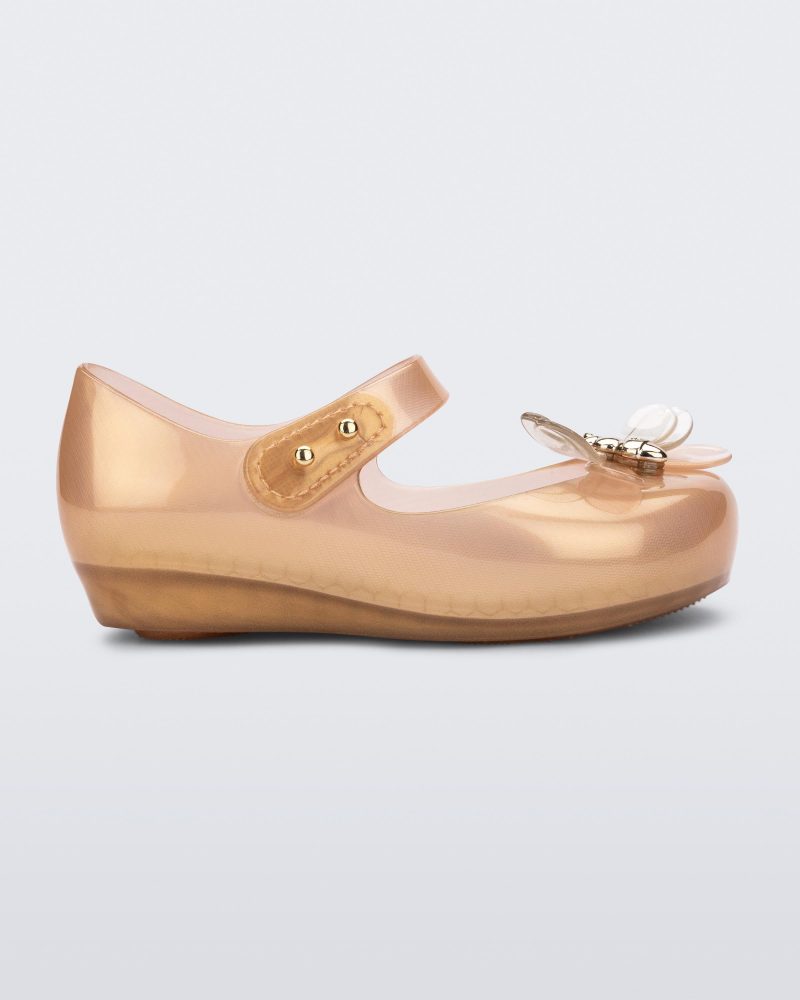 Side view of a pearly orange Mini Melissa Ultragirl Bugs flats with a top strap and bug detail buckle on the toe.