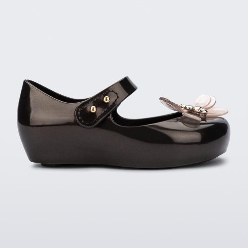 Side view of a metallic black Mini Melissa Ultragirl Bugs flat with a top strap and bug detail buckle on the toe.