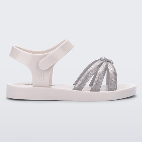 Side view of a white/silver Mini Melissa Precious sandal with three silver glitter front straps joining in the middle and a white ankle strap.