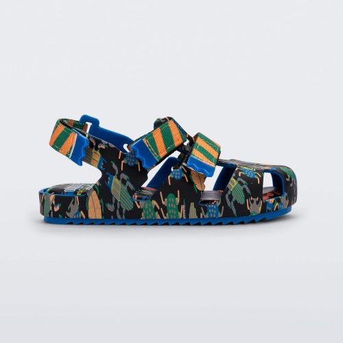 Side view of a blue/green Mini Melissa Yoyo sandal with a black, green and blue patterned base, with two green and orange velcro front straps and an ankle strap.