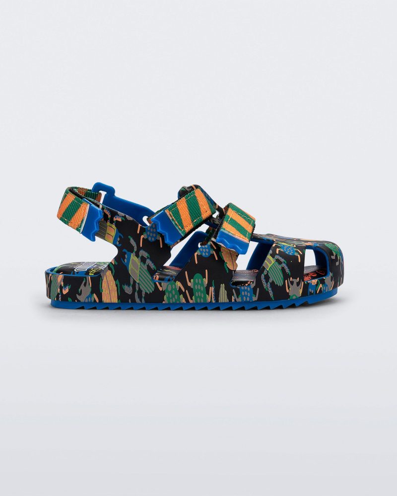 Side view of a blue/green Mini Melissa Yoyo sandal with a black, green and blue patterned base, with two green and orange velcro front straps and an ankle strap.