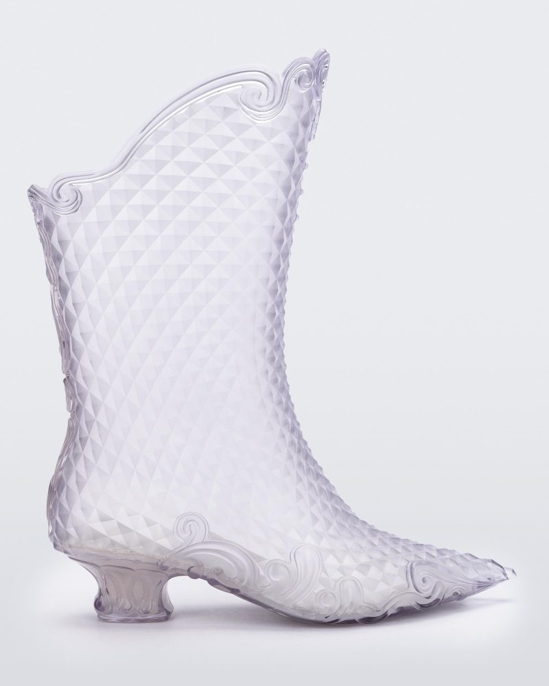 Side view of a pair of transparent glass looking Melissa Court Boots with a short heel, heart detail on the front and a checkered pattern texture.