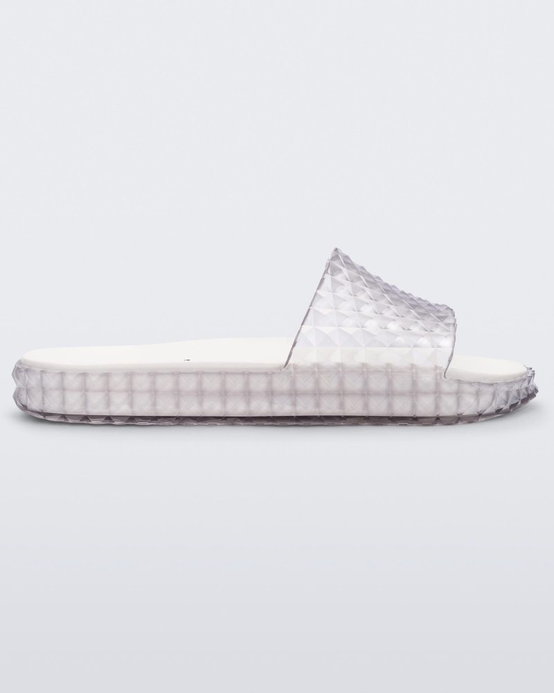 Side view of a clear/white Melissa Court Slide with a checkered pattern texture.