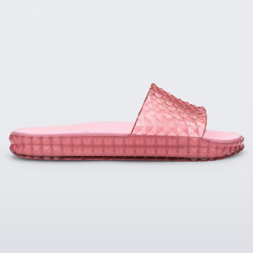 Side view of a transparent pink Melissa Court Slide with a checkered pattern texture.