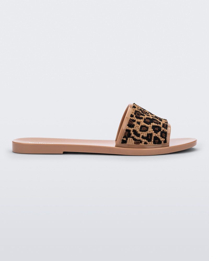 Side view of a beige/black Melissa Savage slide with a cheetah print top strap.